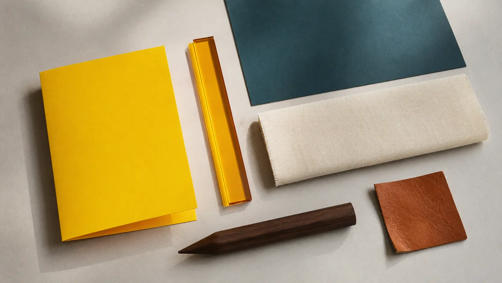 Palette d’application ambre avec papier bleu pétrole, textile ivoire, noyer et cuir cognac