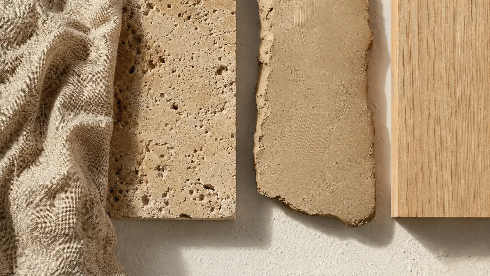 Étude de matières beige : lin tissé, travertin poreux, argile mate et bois clair