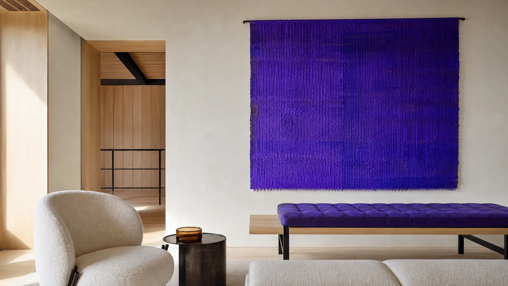 Intérieur contemporain lumineux avec grand panneau textile bleu-violet indigo, murs à la chaux ivoire, assise en laine claire, chêne naturel