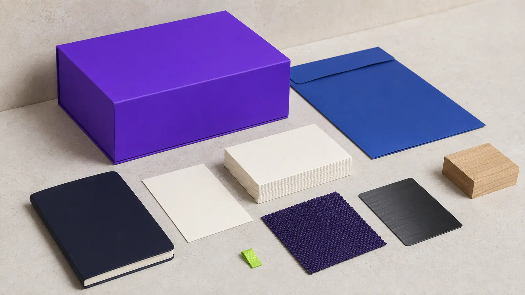 Système d’application indigo sans marque avec boîte bleu-violet, cartes ivoire vierges, carnet bleu nuit, papier cobalt, textile teint