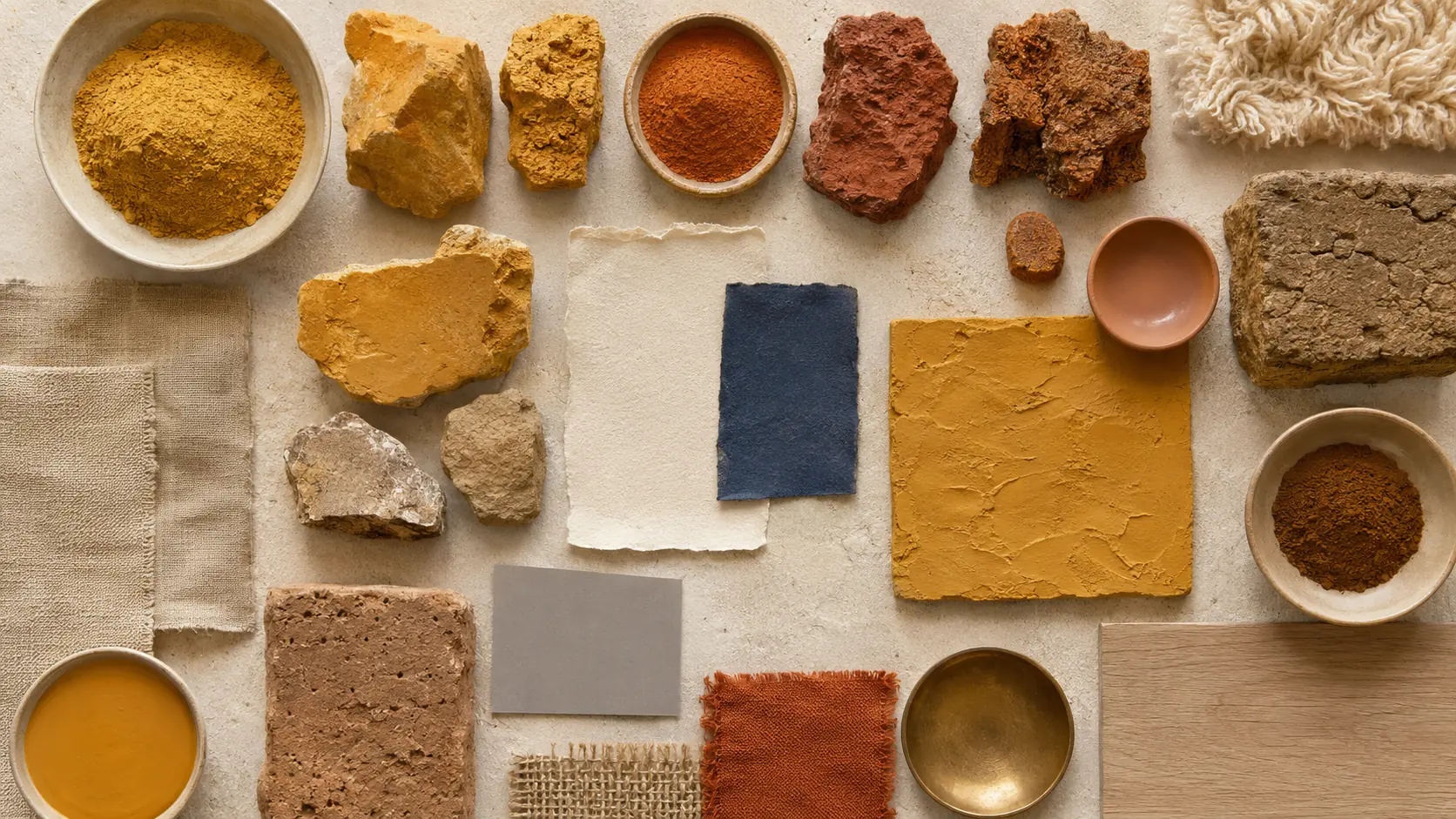 Étude de matières ocre réunissant terres et pierres naturelles jaunes, orangées, rouges et brunes, pigments ocre jaune et rouge, enduit à la chaux, fragments d’adobe, papier artisanal, lin