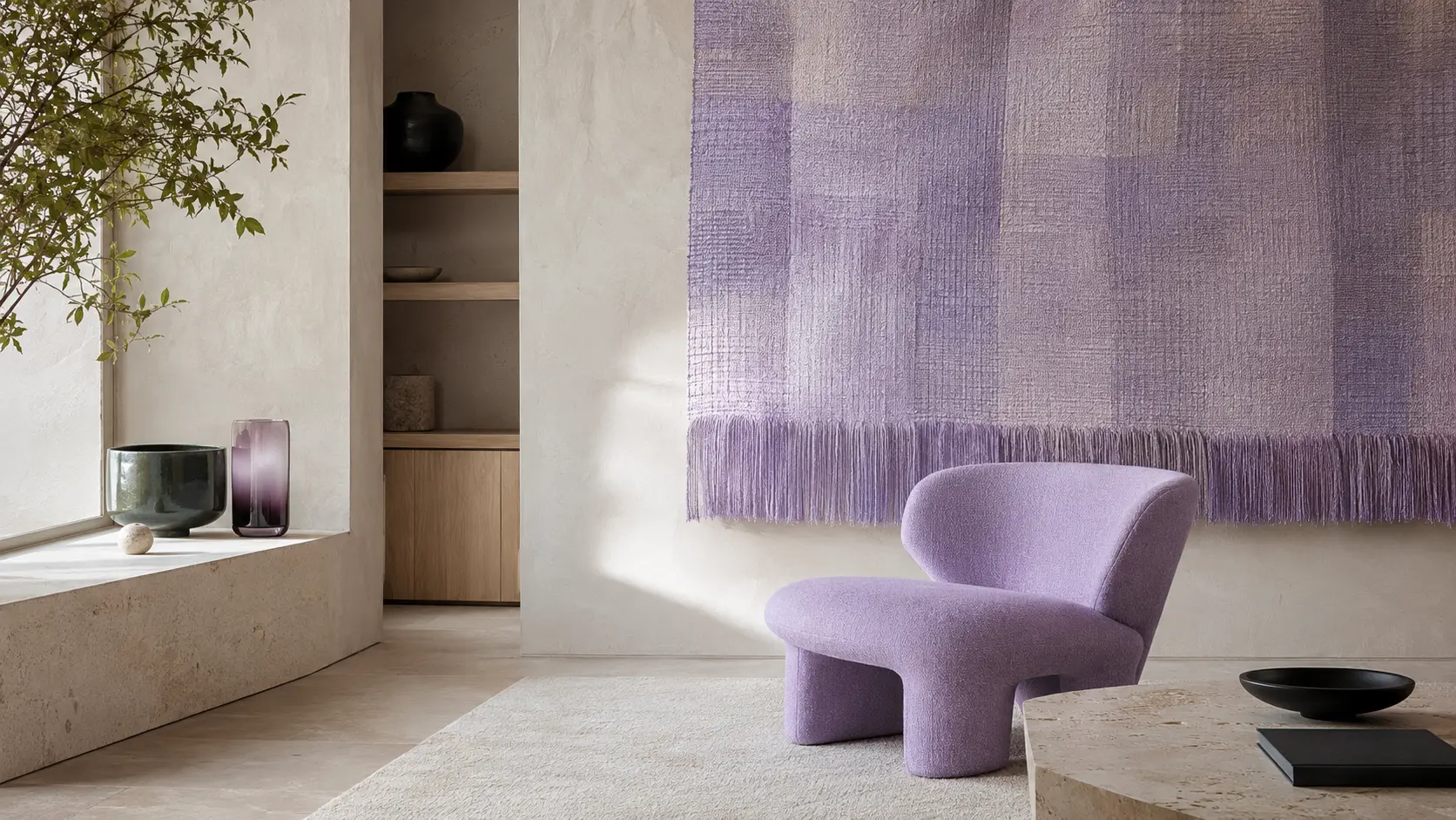 Intérieur contemporain avec grande tenture murale parme, fauteuil sculptural parme, murs ivoire, mobilier en frêne clair, sol calcaire, objet en céramique vert forêt et verre violet fumé