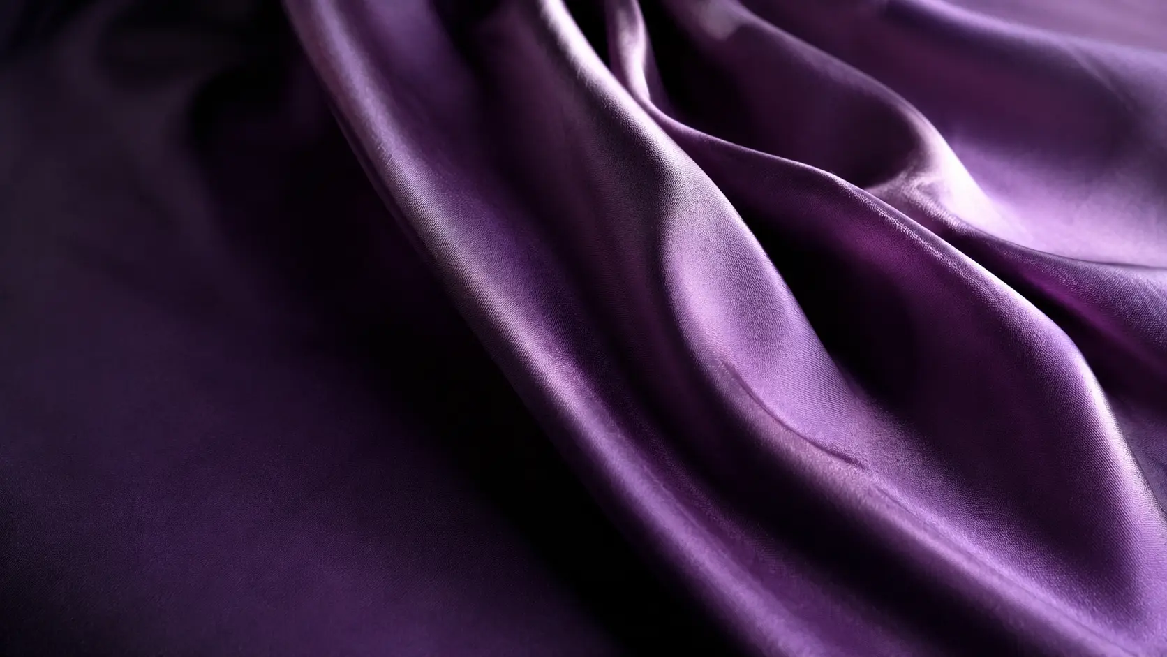 Étoffe violette satinée montrant les variations de couleur créées par les plis et la lumière